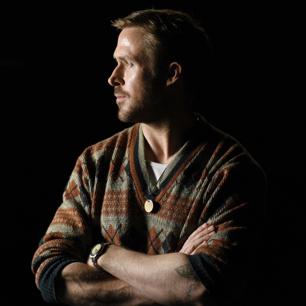 Актер Райан Гослинг в свитере на черном фоне 