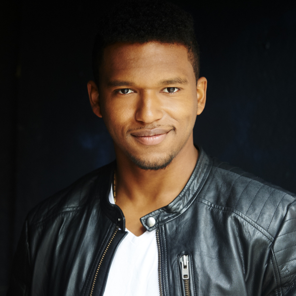 Красивый мужчина в черной куртке, актер Ловелл Адамс-Грей