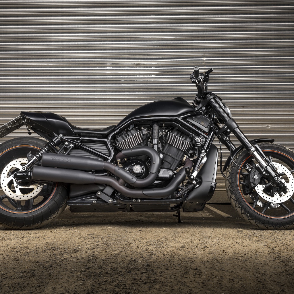 Черный тяжелый мотоцикл Harley-Davidson у гаража