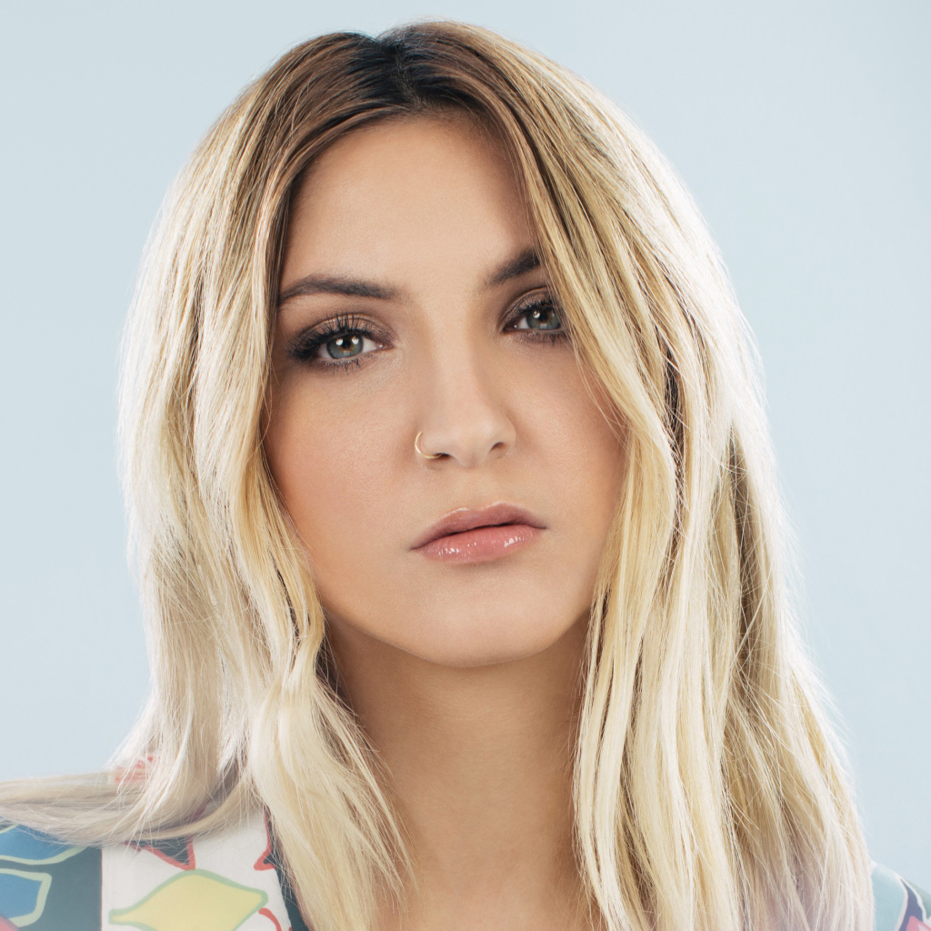 Красивая блондинка, певица Джулия Майклз на сером фоне