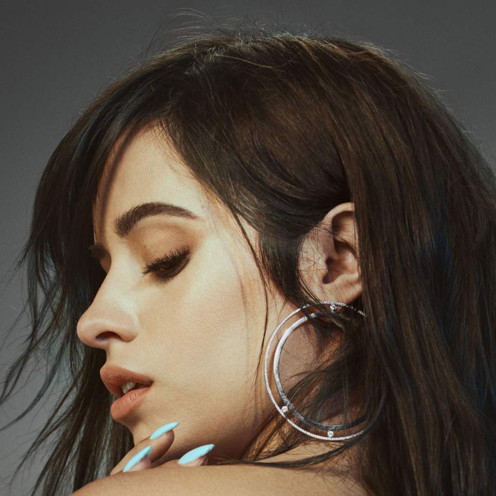 Певица Камила Кабельо на сером фоне крупным планом 