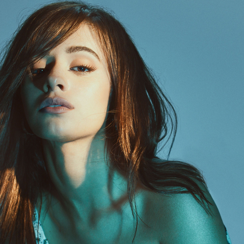 Молодая кареглазая певица Камила Кабельо на синем фоне