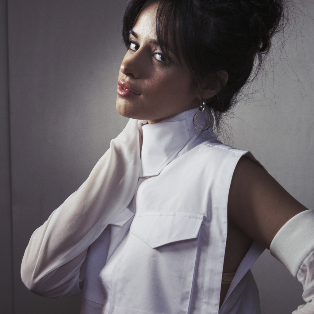 Молодая певица Камила Кабельо в белом костюме у стены