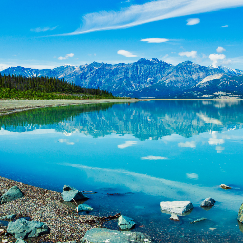 Красивое голубое озеро у заснеженных гор