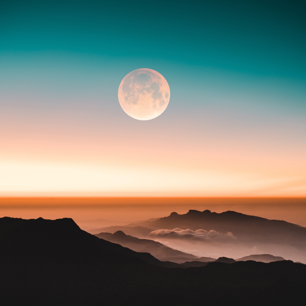 Большая круглая луна в ночном небе над холмами