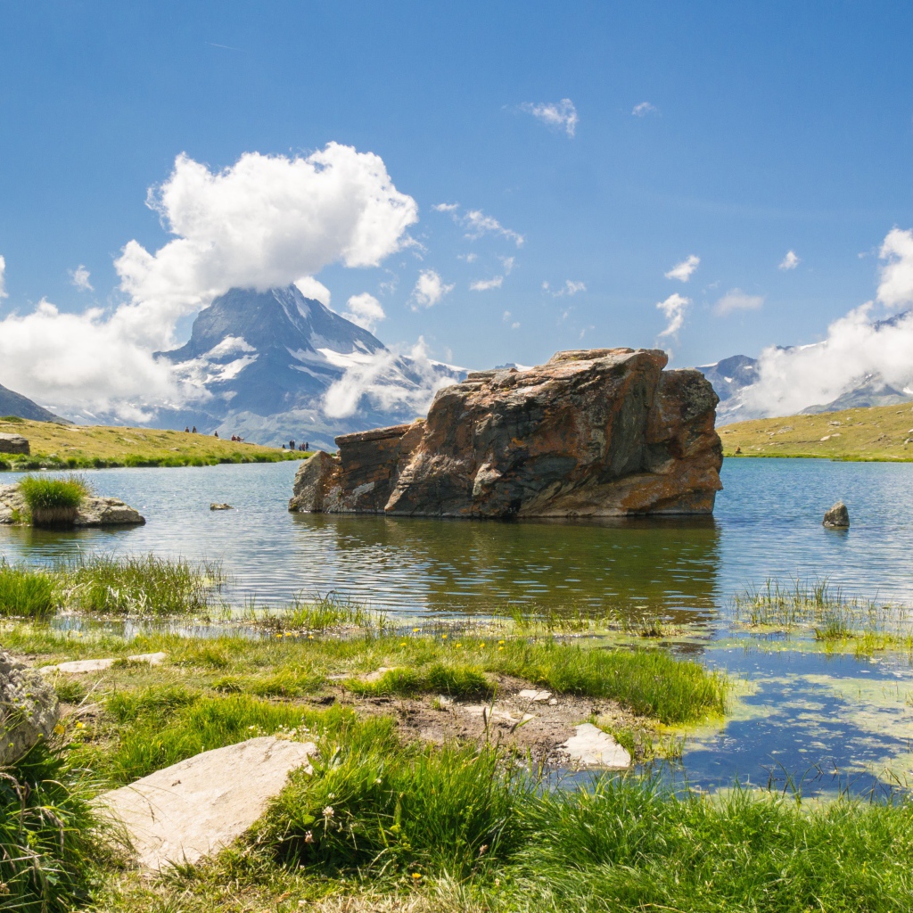 Большой камень в воде на фоне голубого неба