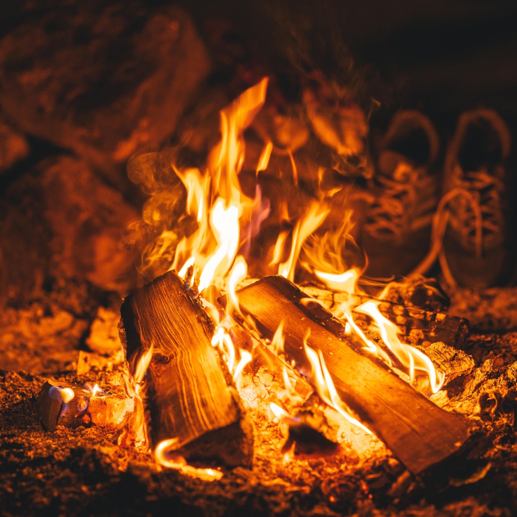Дрова лежат в ярком огне костра