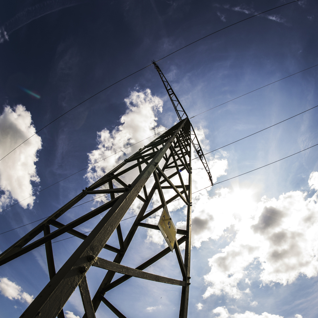 Столб линии электропередач на фоне голубого неба с облаками