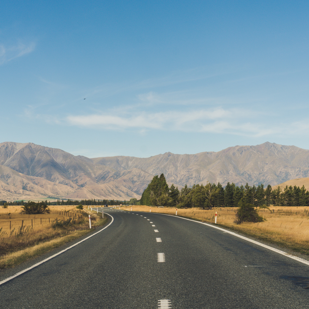 Ровная асфальтовая дорога на фоне гор 