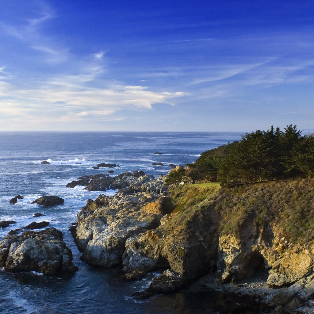 Каменные скалы береговой линии в океане под голубым небом
