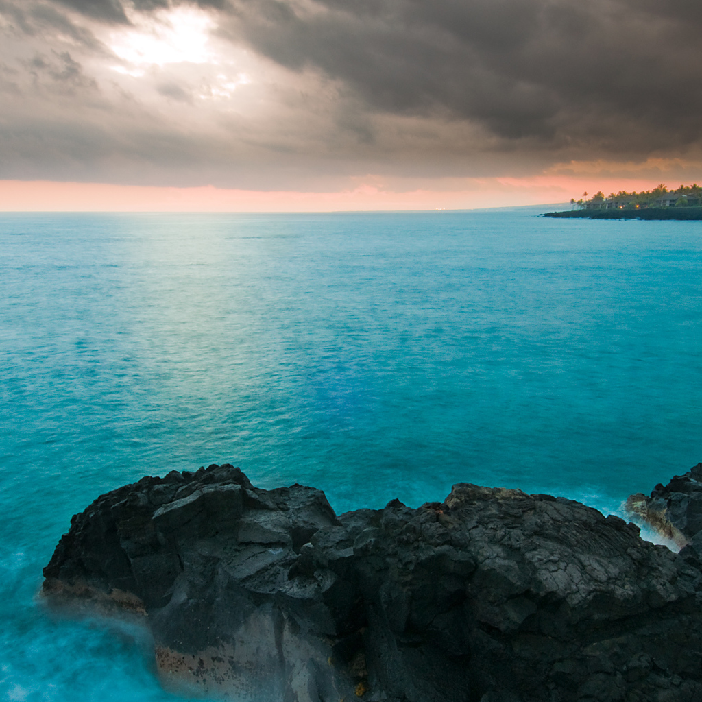 Камни в голубой воде океана под пасмурным небом