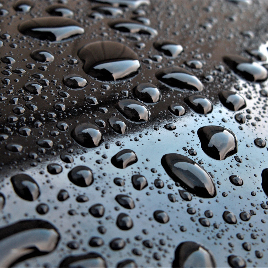 Капли воды на черной глянцевой поверхности 