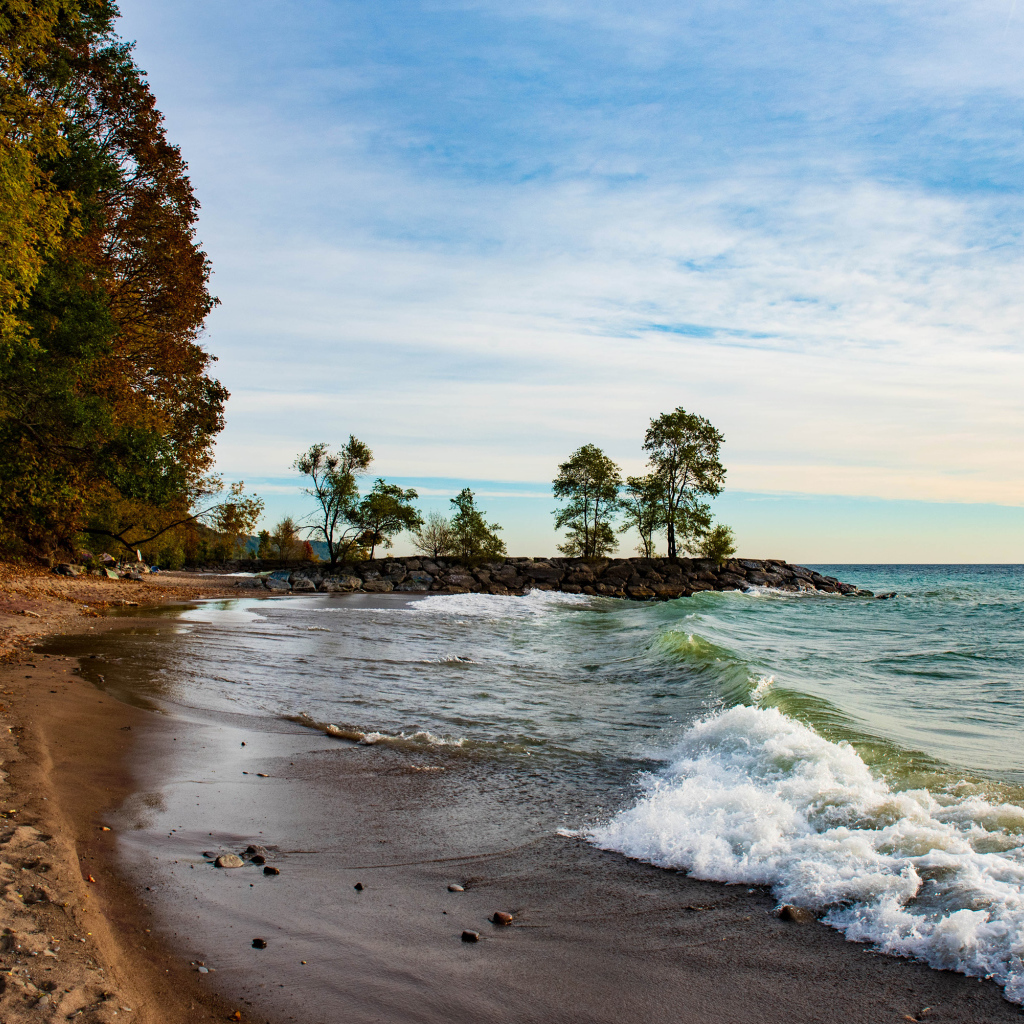 Белые волны океана на мокром песке под красивым небом