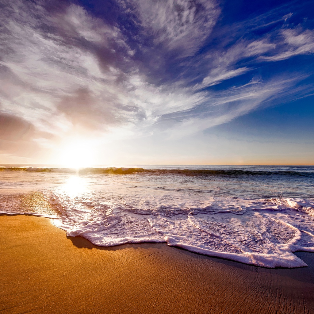 Красивые белые морские волны на теплом песке летом
