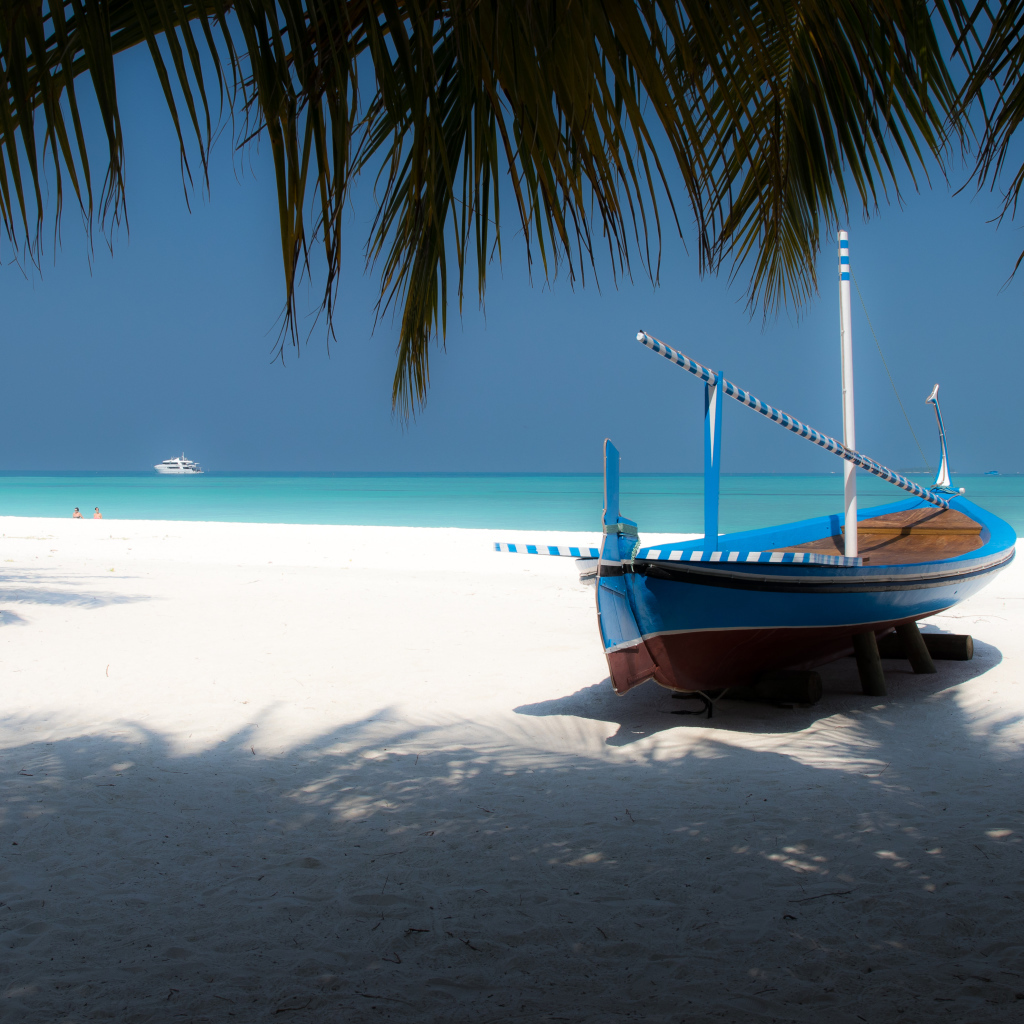 Лодка на белом песке у океана в тропиках
