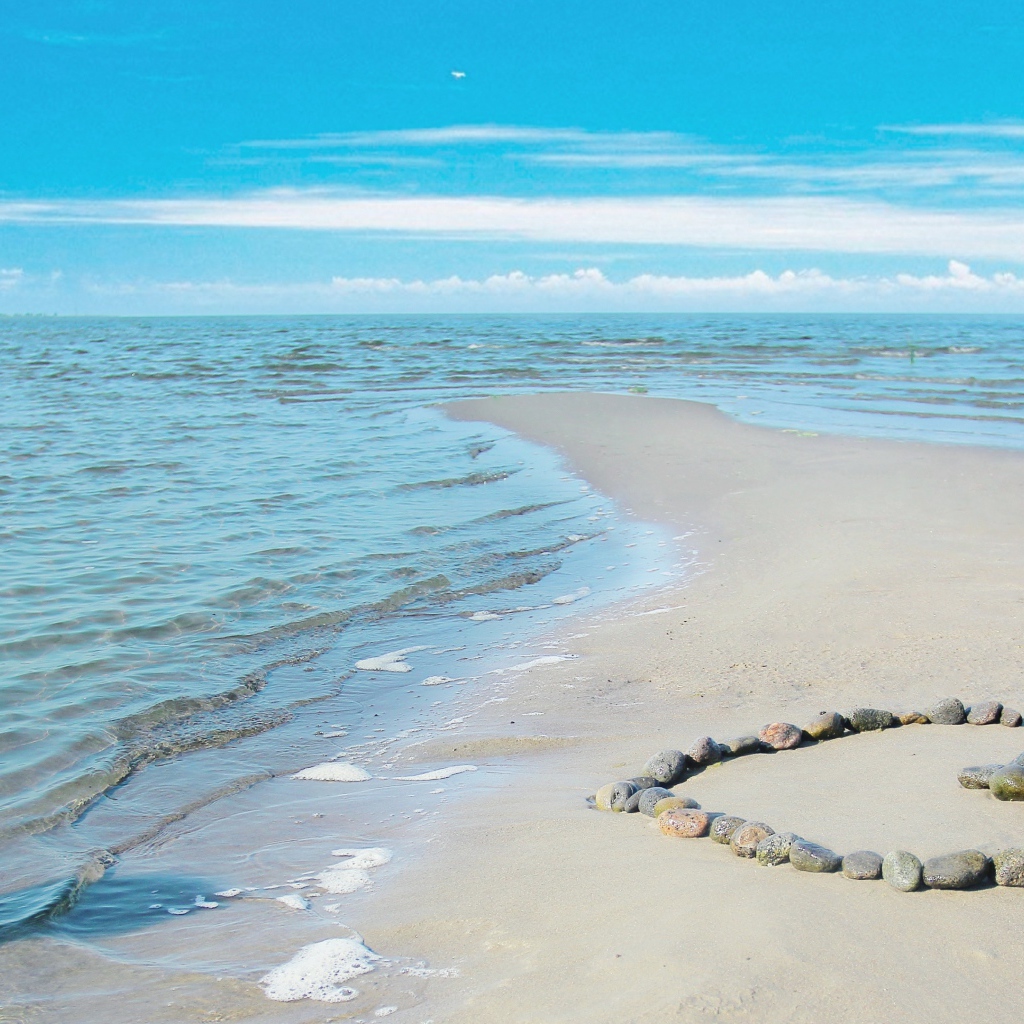 Сердце из камней на берегу теплого моря летом
