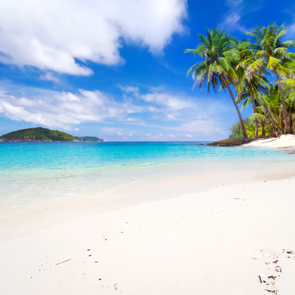 Белый песок на тропическом пляже с голубой водой 