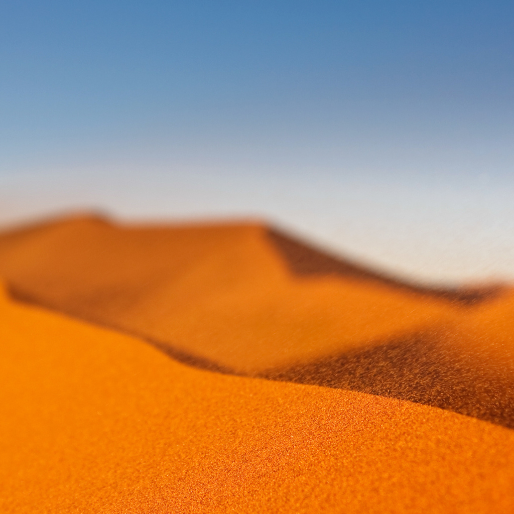 Желтый песок в пустыне под голубым небом