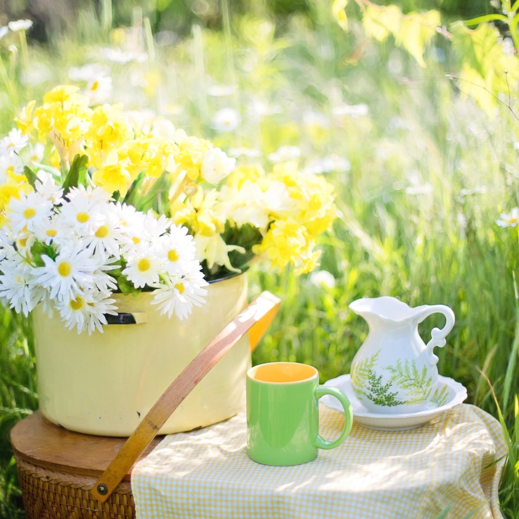 Букет цветов в кастрюле стоит на корзине 