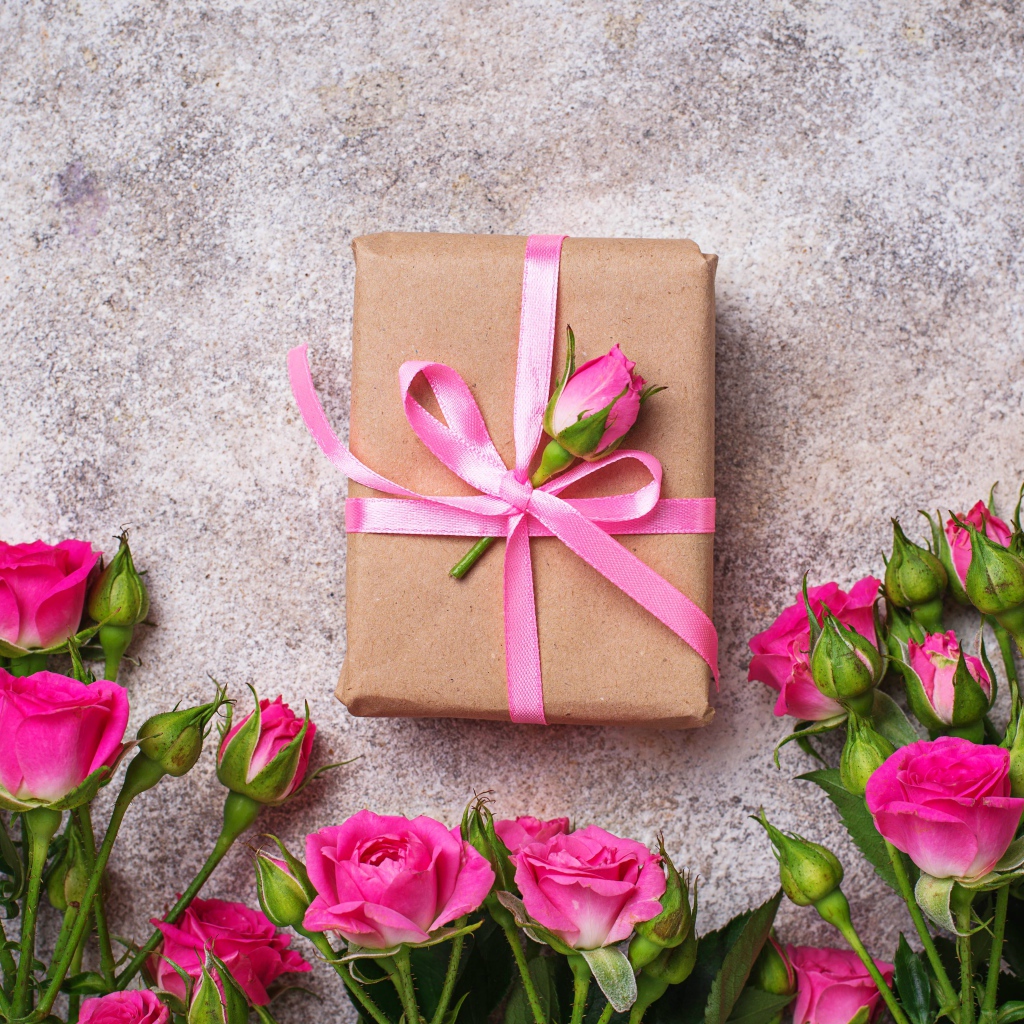 Подарок на сером фоне с букетом розовых роз