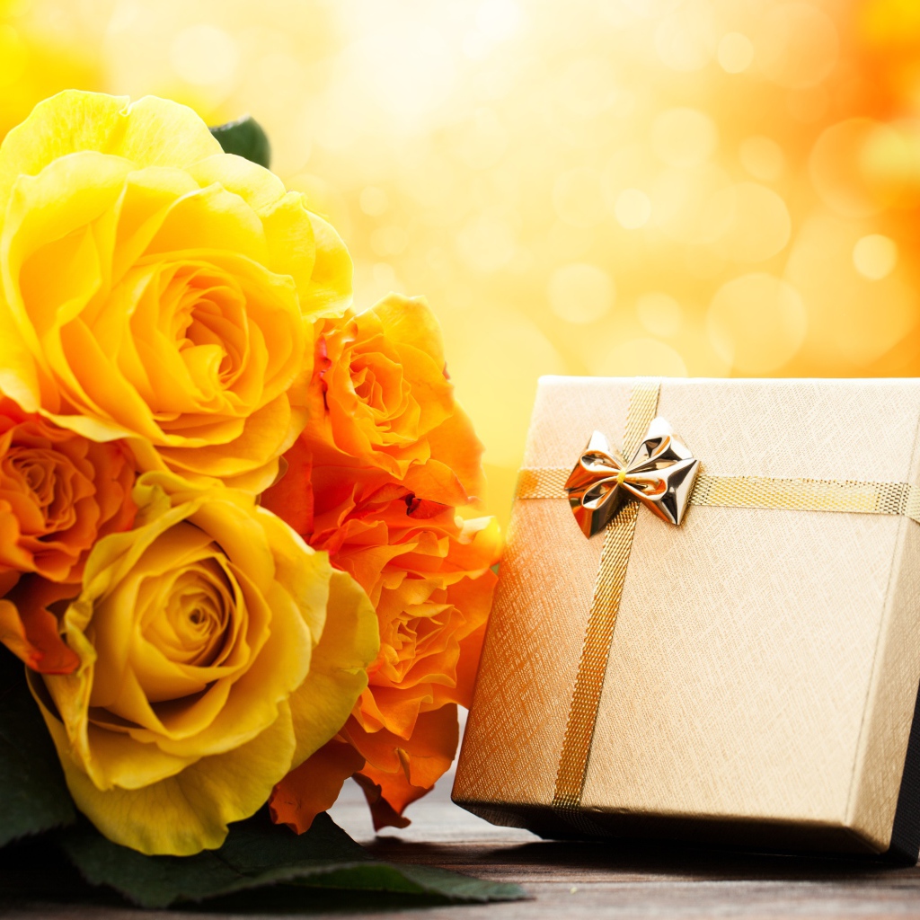 Подарок с букетом желтых роз на столе 