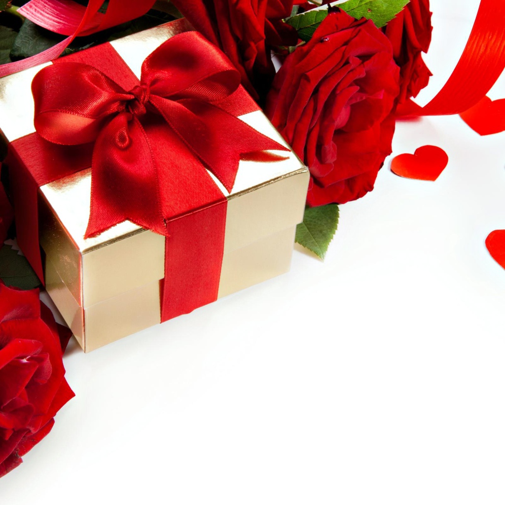 Подарок с красным бантом на белом фоне с красными розами и сердечками