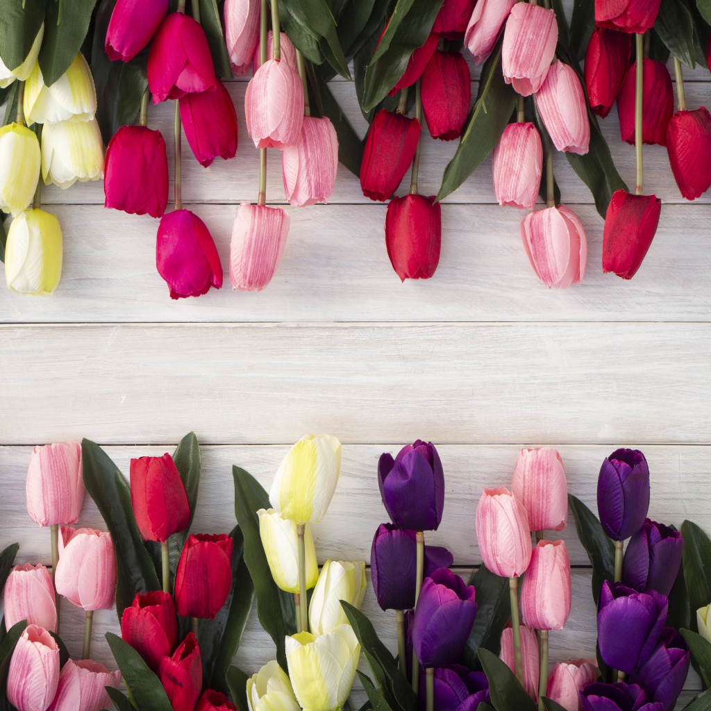 Искусственные разноцветные тюльпаны на деревянной поверхности