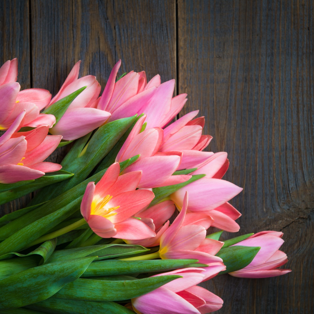 Красивый букет розовых тюльпанов на деревянном столе