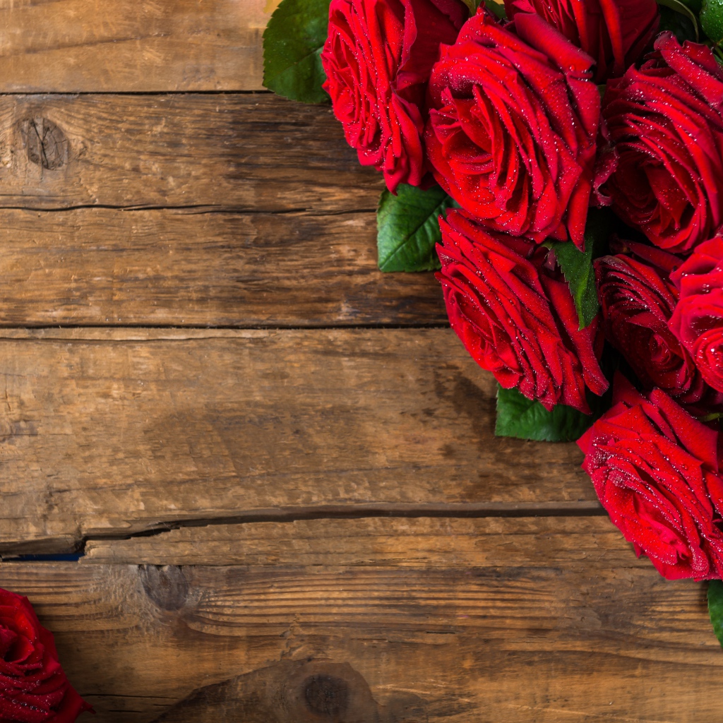 Красивый букет красных роз на деревянном фоне
