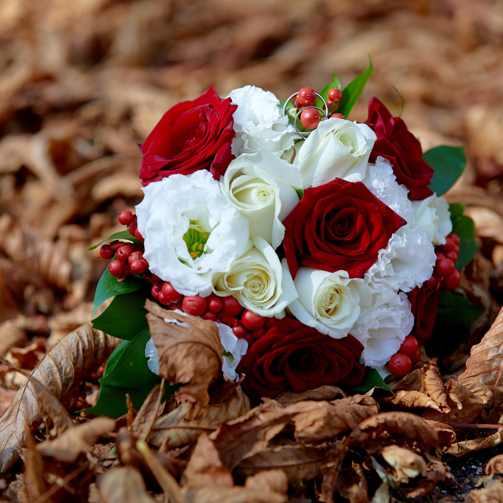 Красивый свадебный букет лежит на сухой траве