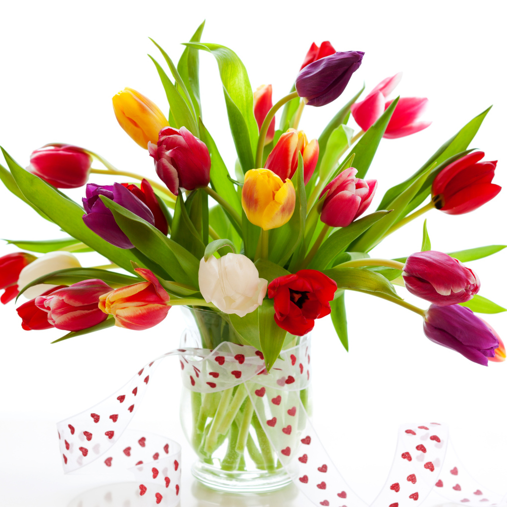 Букет разноцветных тюльпанов в прозрачной вазе с лентой 