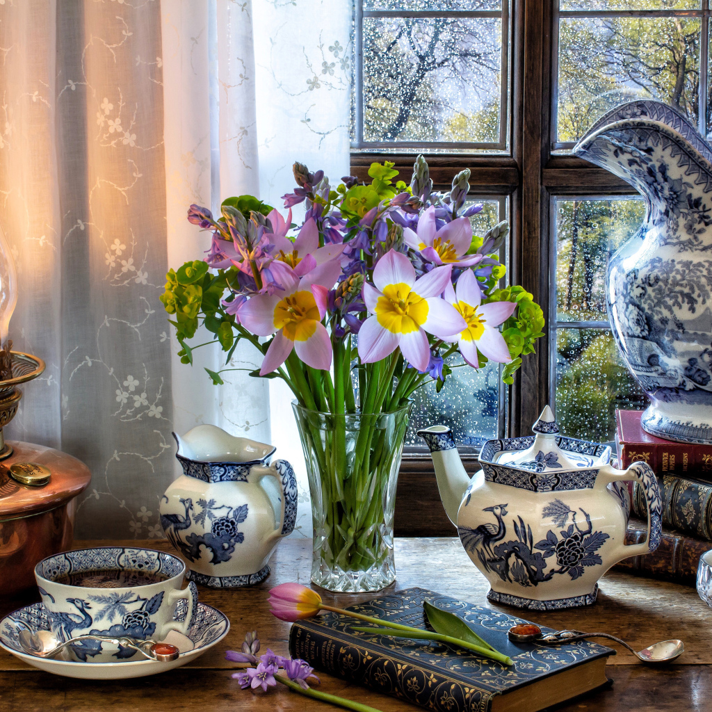 Букет цветов в вазе на столе с красивым сервизом