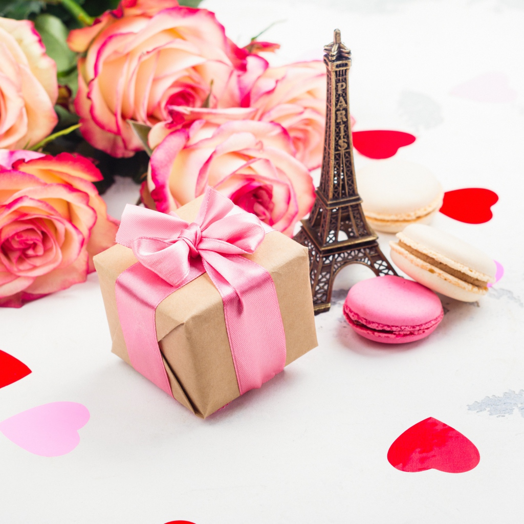 Букет роз на столе с фигуркой Эйфелевой башни и подарком