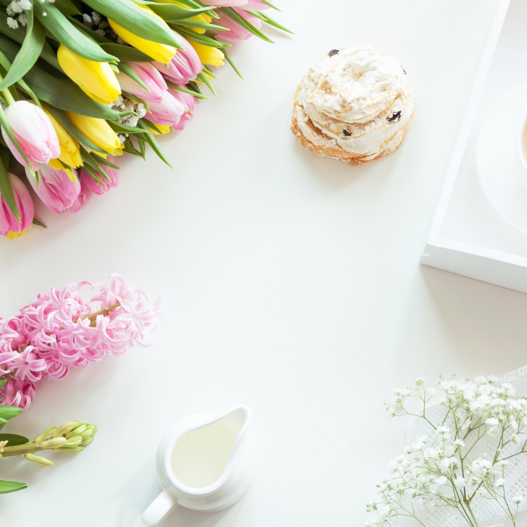 Букет тюльпанов и гиацинт на столе с пирожным и чашкой какао 