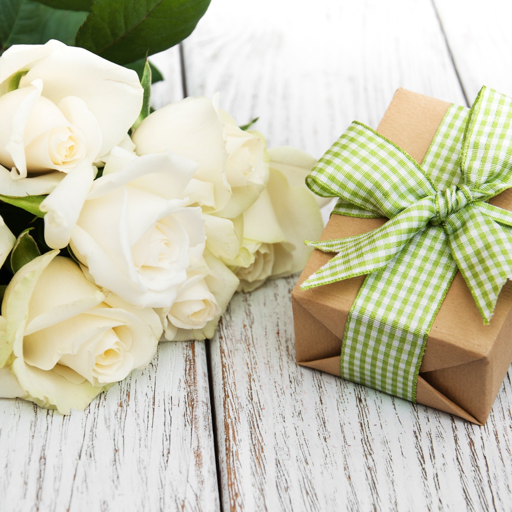 Букет белых роз на столе с подарком