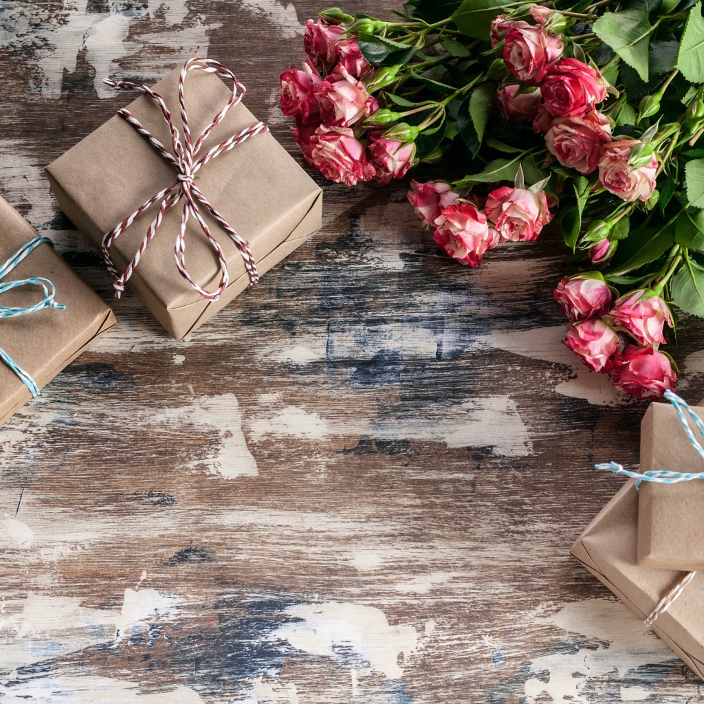 Подарочные коробки на деревянной поверхности с букетом роз