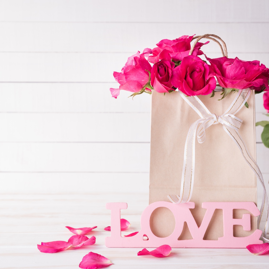 Пакет с розами на столе с надписью Love