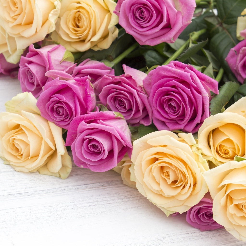 Розовые и белые розы на белом столе 