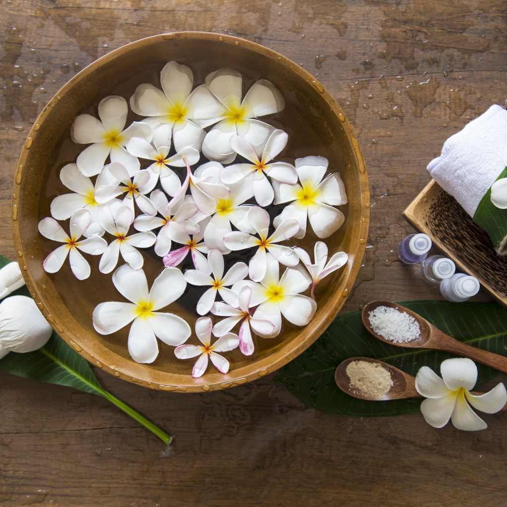 Цветы плюмерии в чаше с водой для SPA процедур 