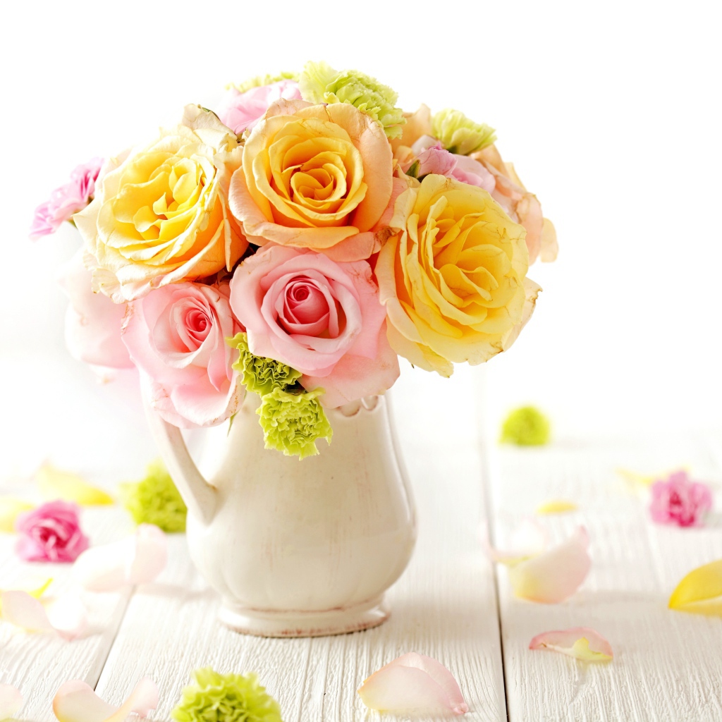 Желтые и розовые розы в вазе на столе 