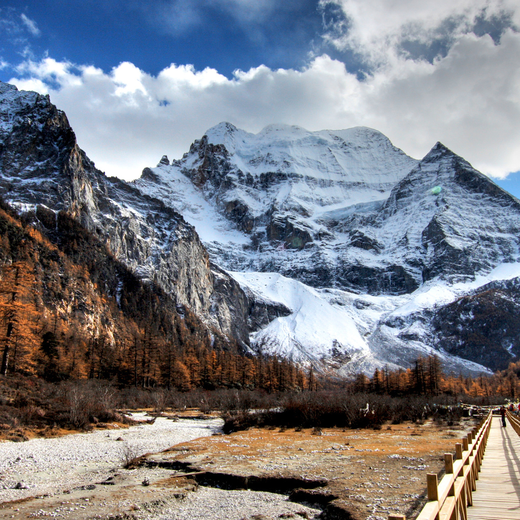 A bridge at the foot of snowy majestic mountains