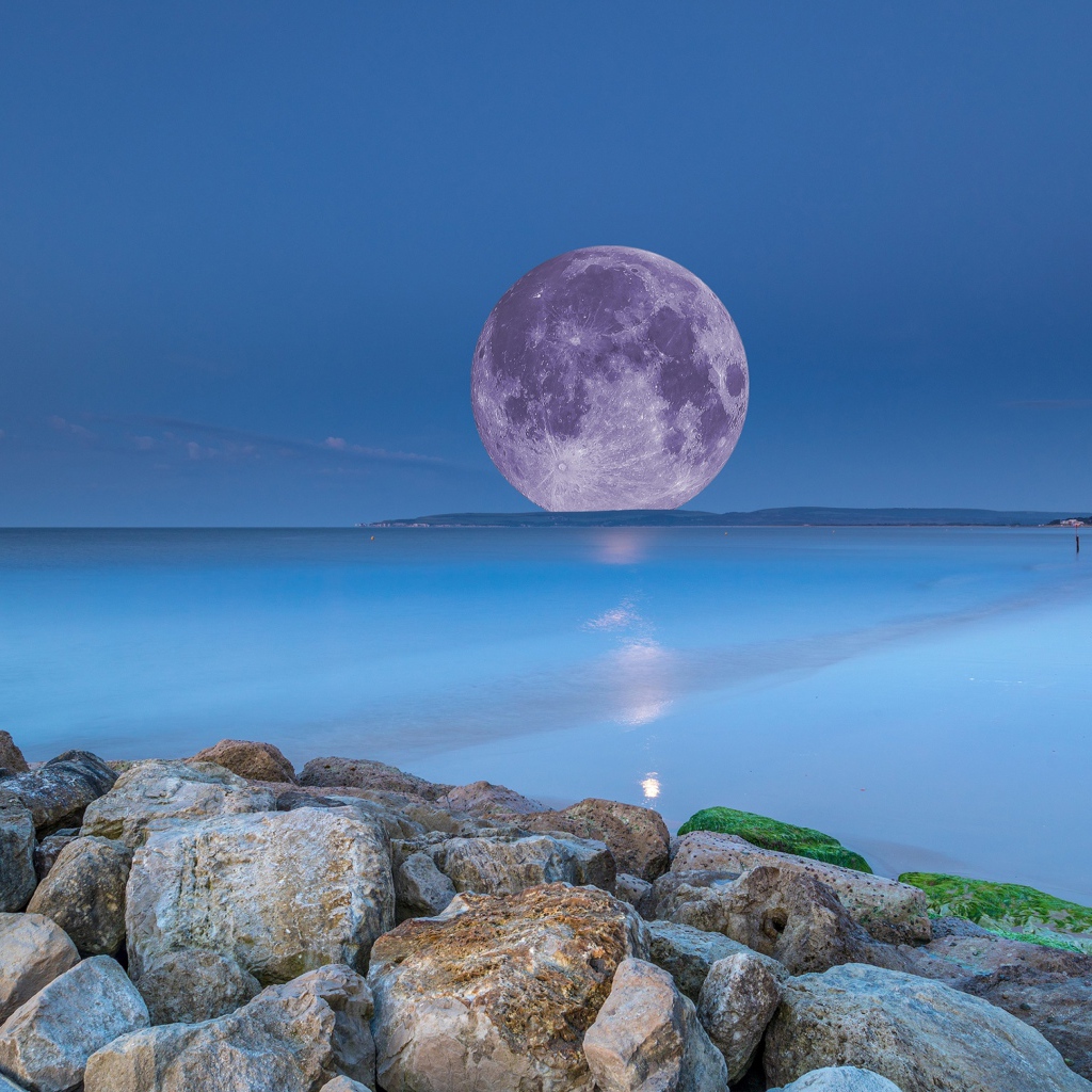 Огромная белая луна на горизонте в море