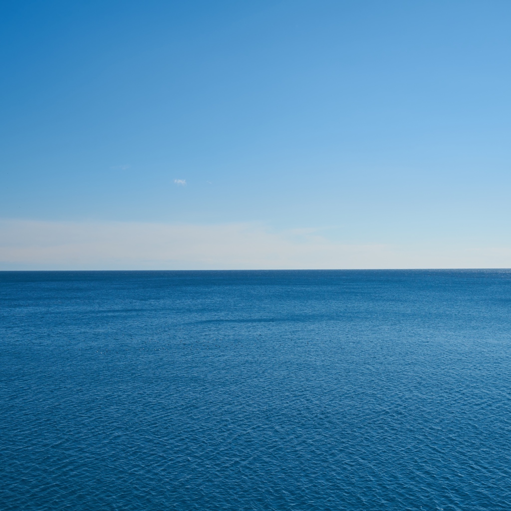 Спокойная морская вода на фоне голубого неба 