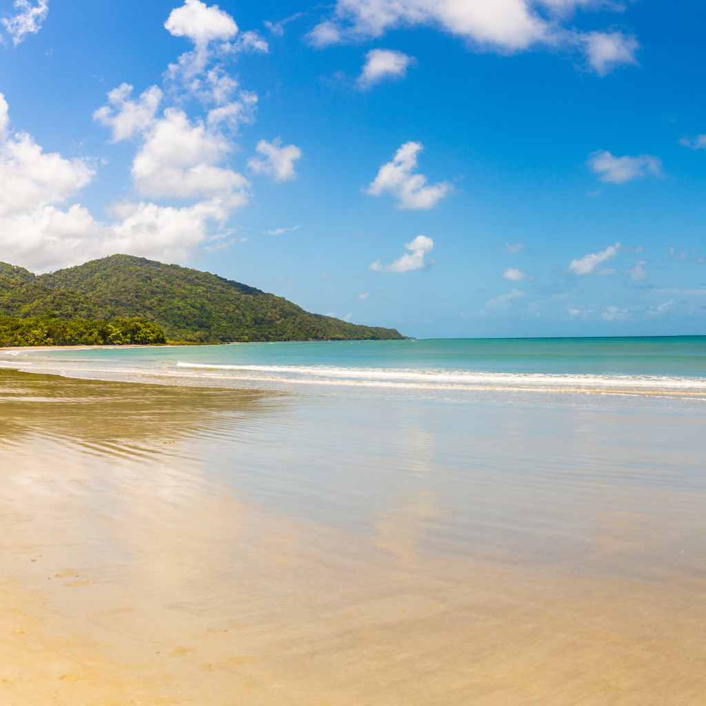 Спокойные волны на песке под красивым голубым небом