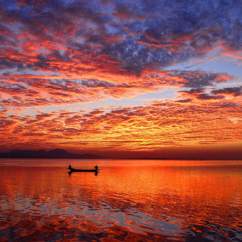 Лодка на воде спокойного озера на закате