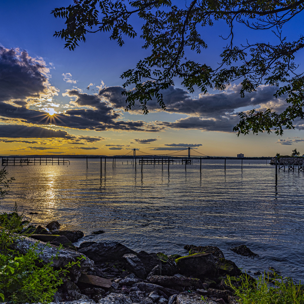 Солнце садится за тучи на горизонте в море