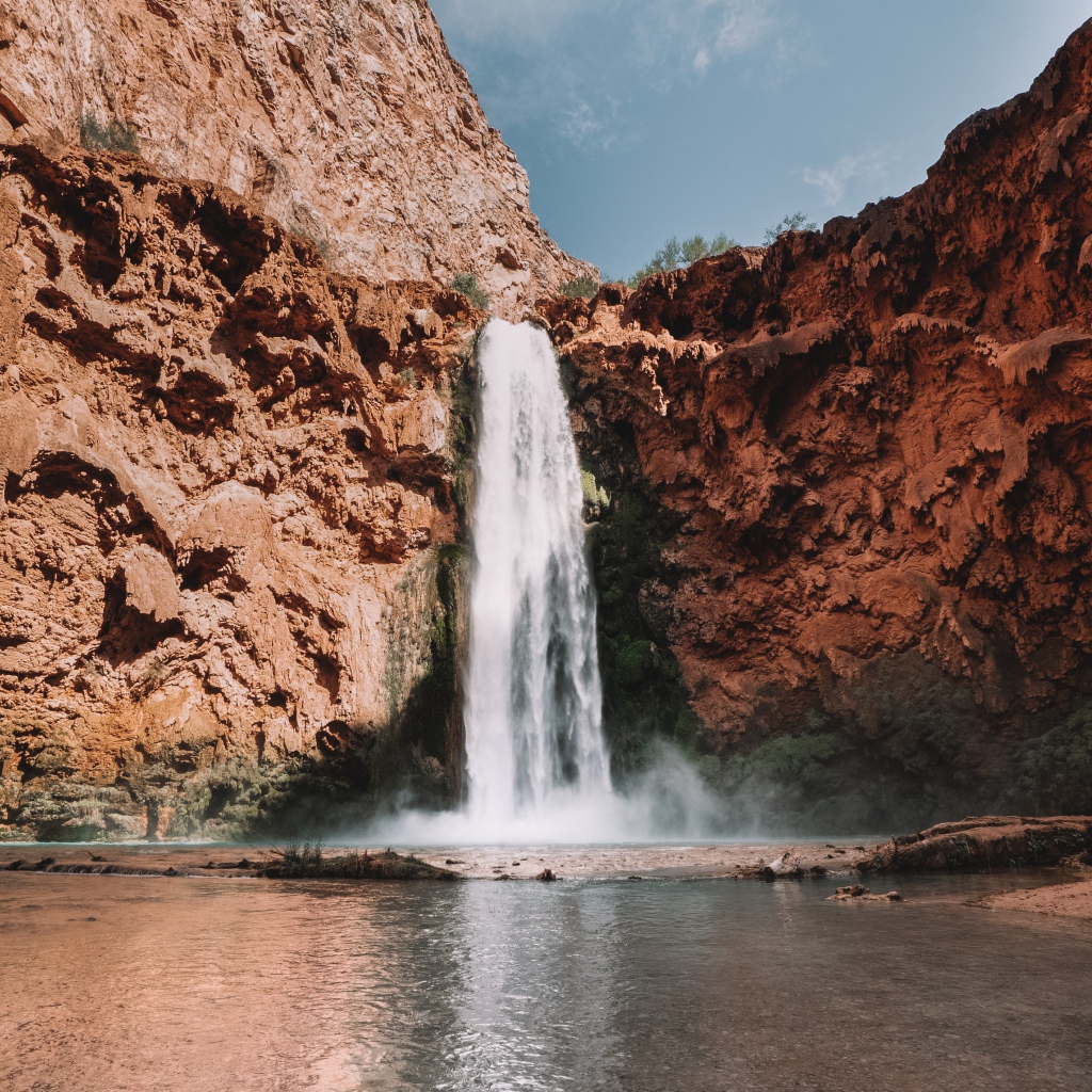 Водопад стекает со скалы в озеро 