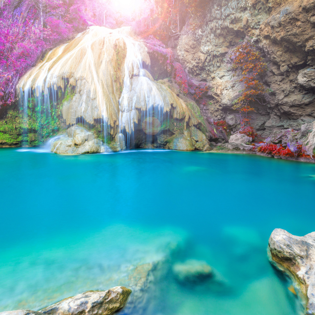 Водопад стекает по скале в голубую воду, Тайланд