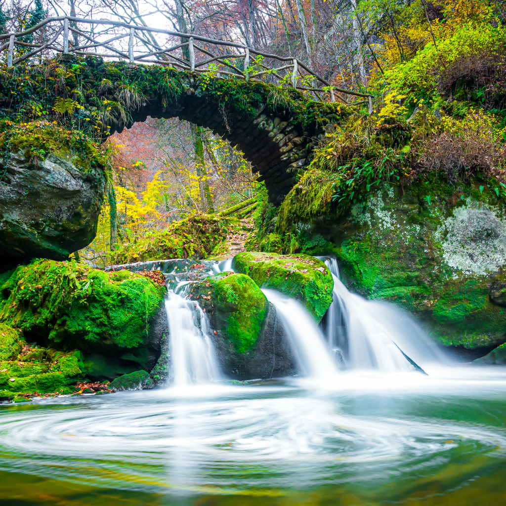Водопад под старым покрытым мхом мостом