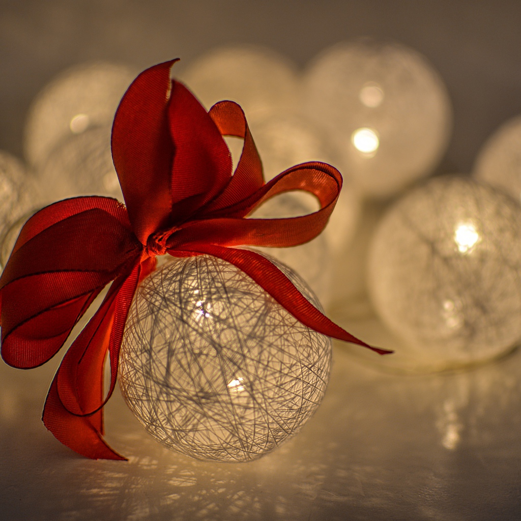 Красивый елочный шар с белых нитей с красным бантом